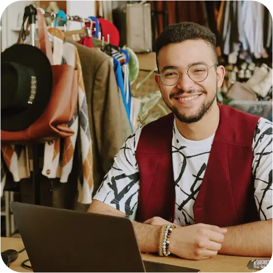 man smiling working at a laptop