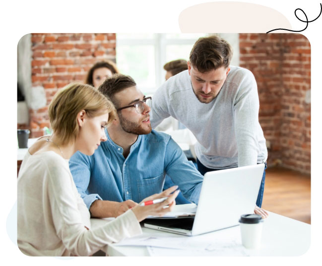 A diverse group of professionals collaborating on a laptop in a modern office setting.